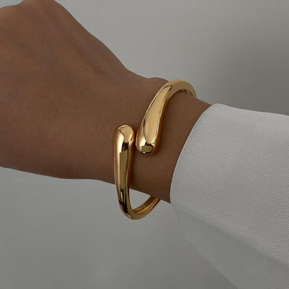 Polished Gold-Tone Bangle Bracelet with Elegant Curve