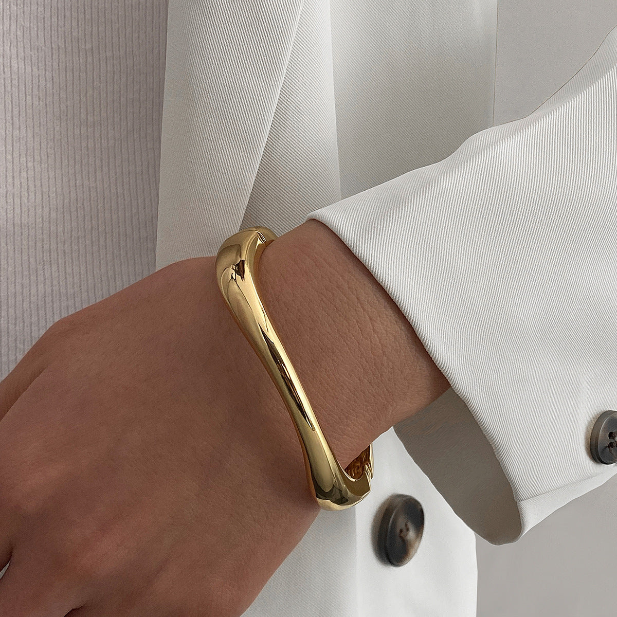 Polished Gold-Tone Bangle Bracelet with Elegant Curve